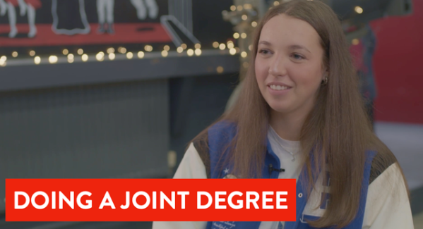 Student smiling by some fairy lights